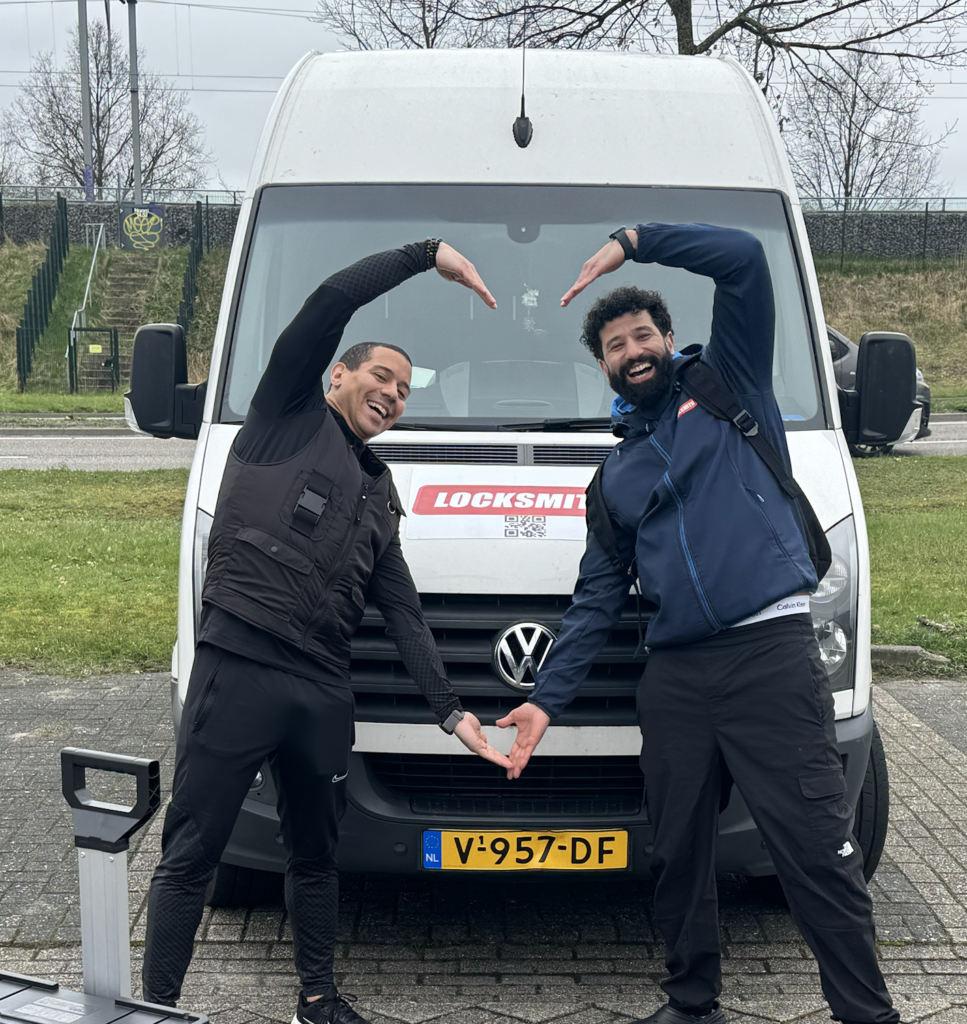 Twee mannen poseren vrolijk voor een slotenmakersbusje.