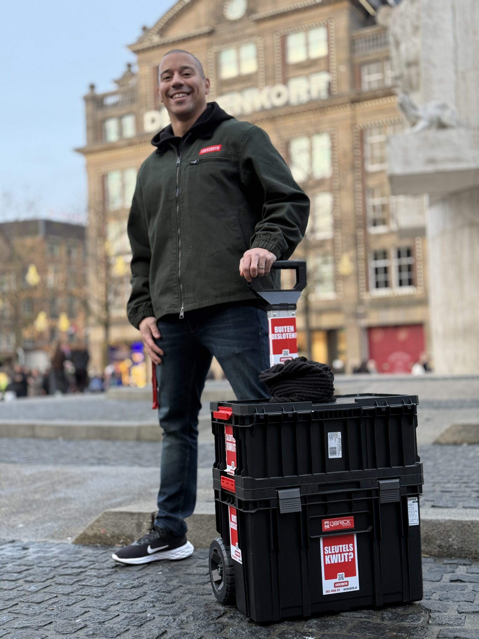 Man met gereedschapskoffer op stadsplein