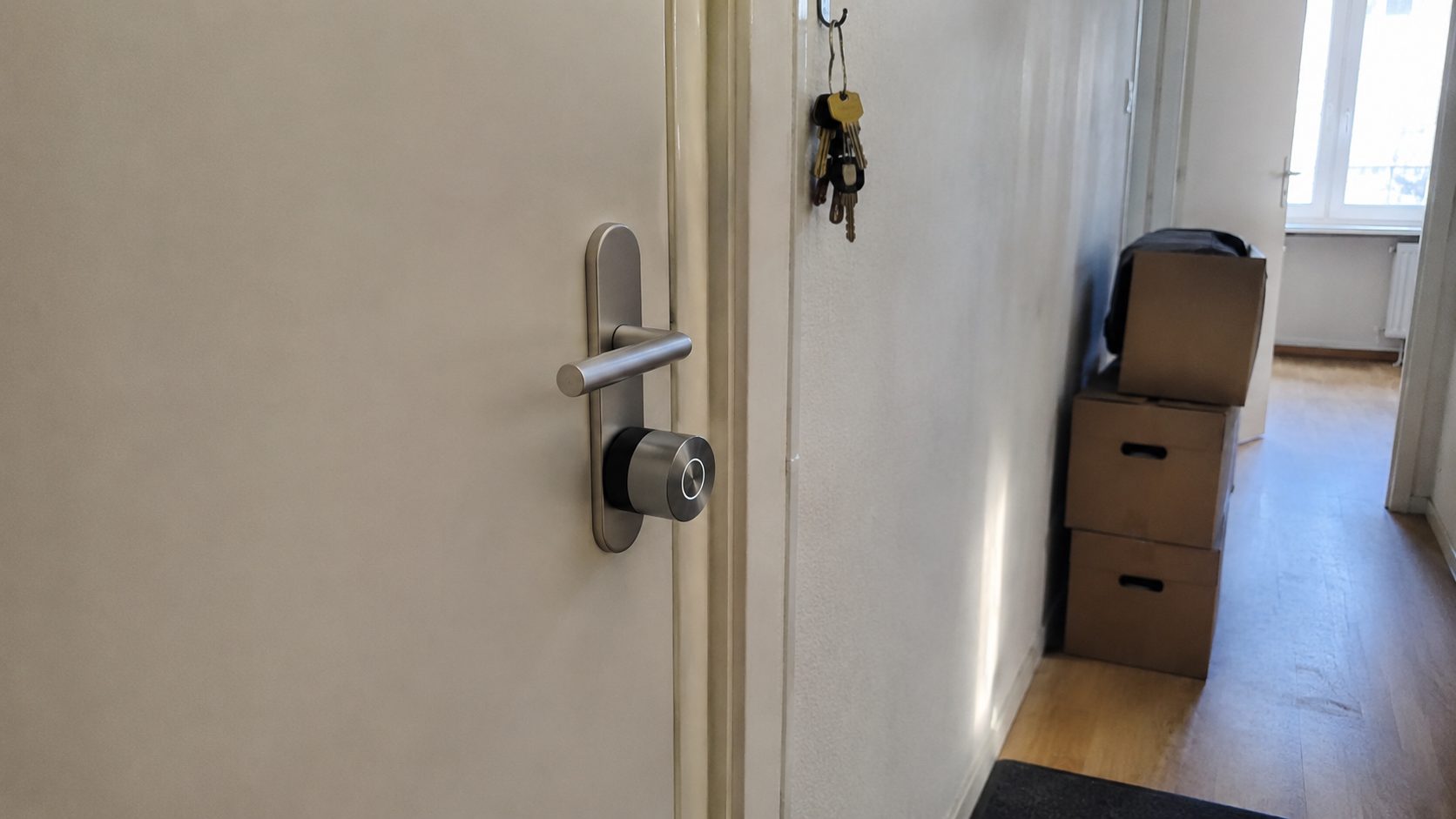 Slim slot op de binnenkant van een voordeur in een huurwoning, met verhuisdozen op de achtergrond