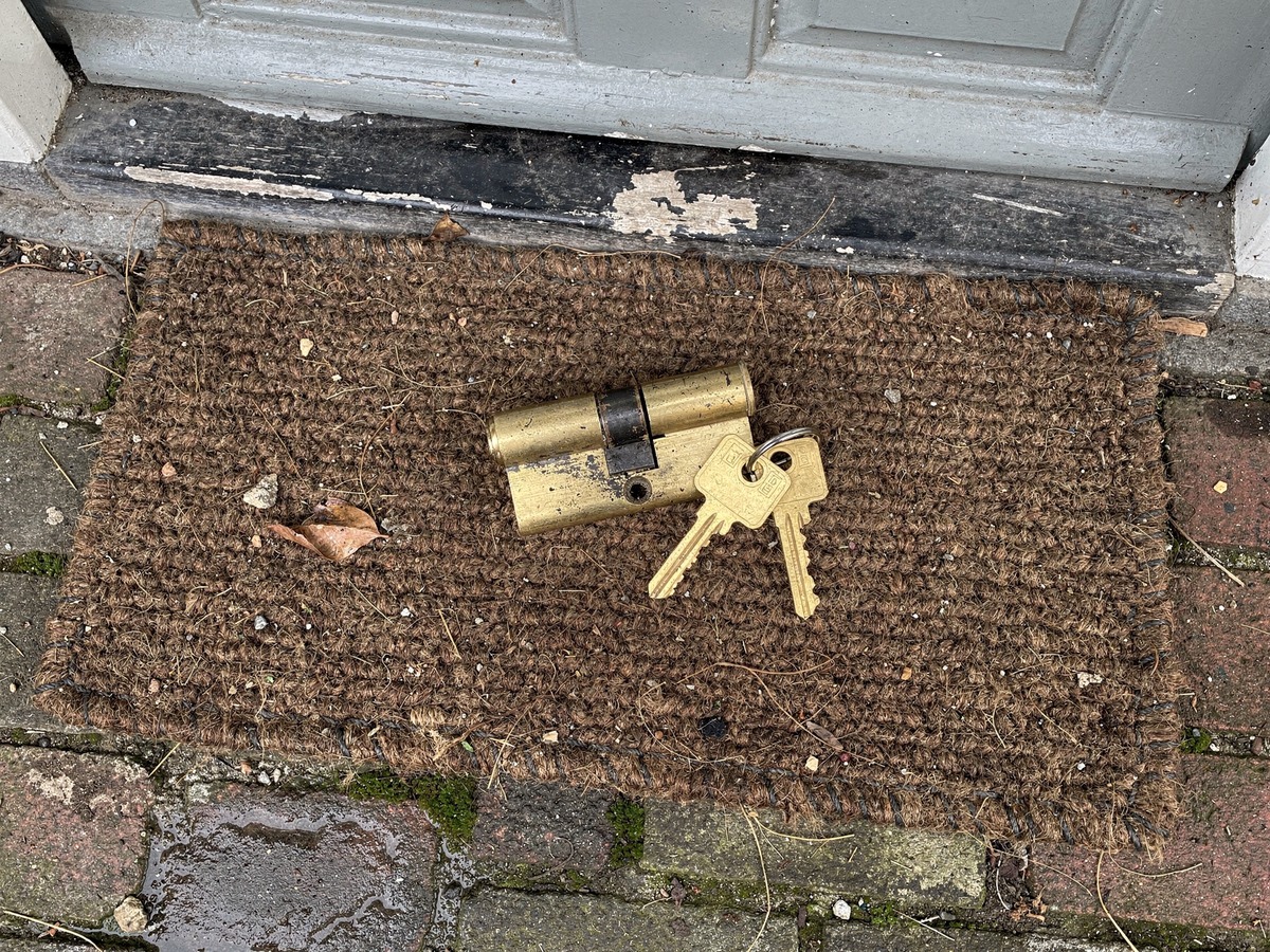 Euro profile cylinder and two keys lying on the doormat of a Dutch rental home